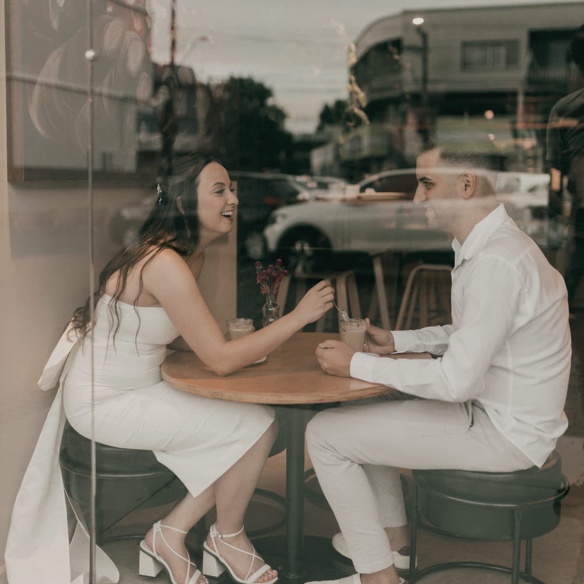 Pareja de novios conversando en un café mientras planean su boda